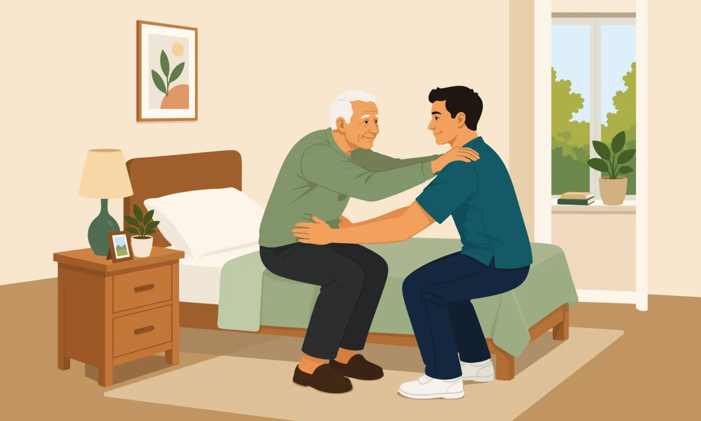 Caregiver supporting an elderly man at the hips as he prepares to stand from his bed